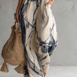 Macacão pantalona com estampa em lavagem de tinta, decote halter e bolsos.
